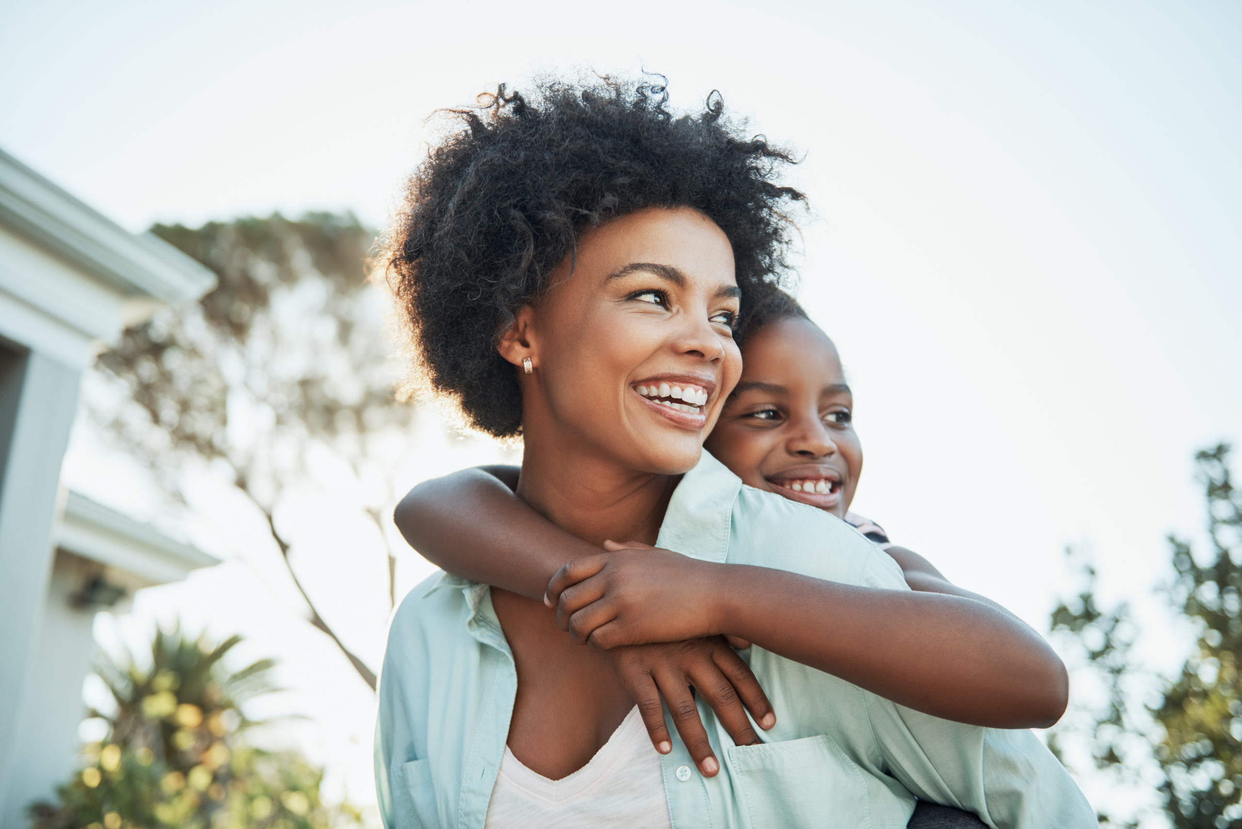 Shot of a cheerful young mother giving her little daughter a piggyback ride outside during the day